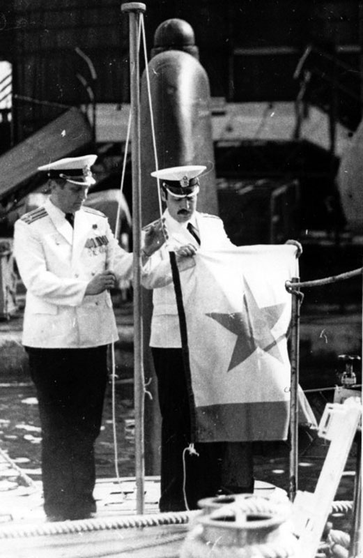 Командир Зеленский Ю.А. и инженер дивизиона живучести Ульянов А.В. поднимают военно-морской флаг.